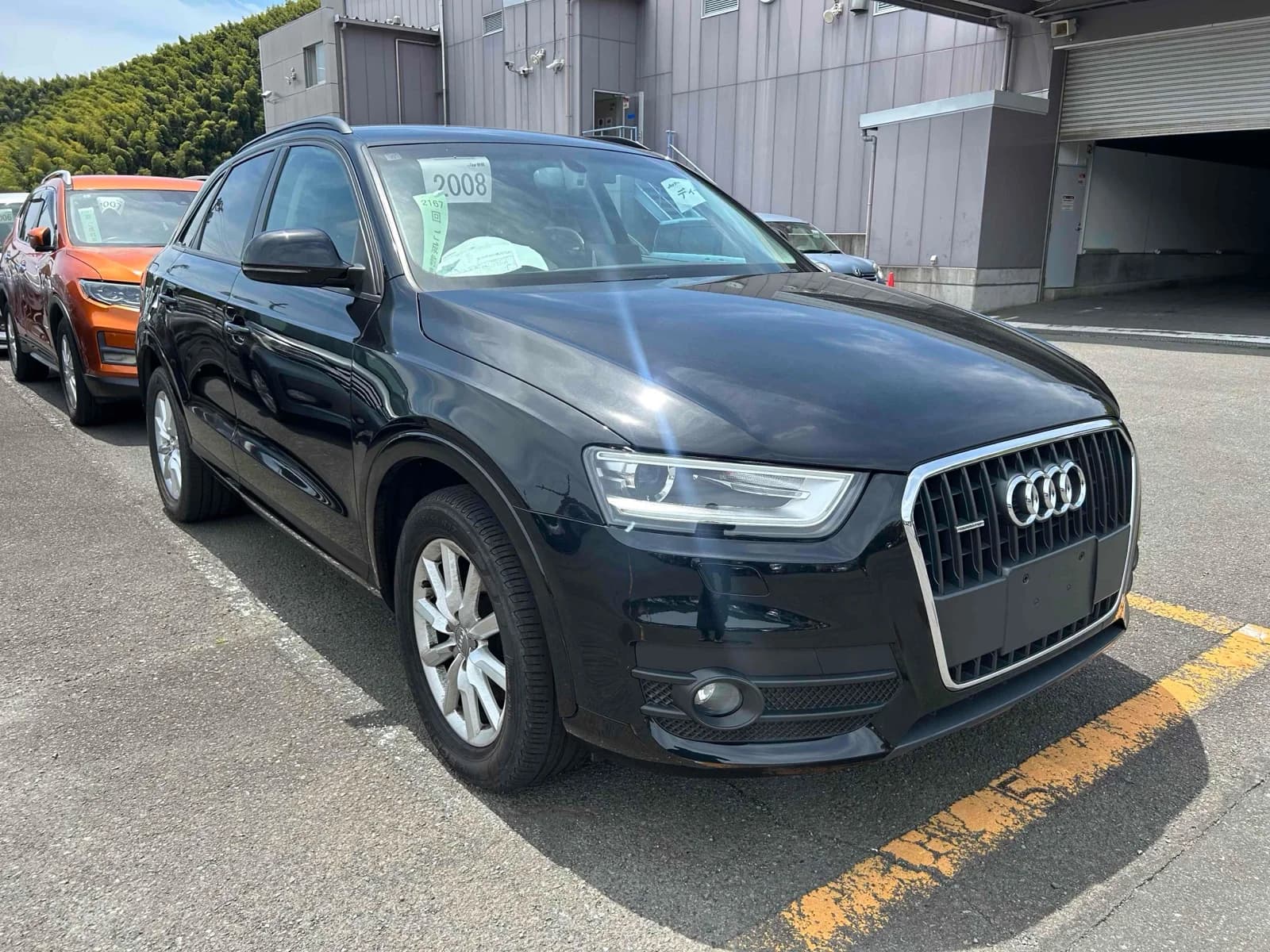 Front three-quarter view of a black Audi Q3 SUV parked in an outdoor auction lot