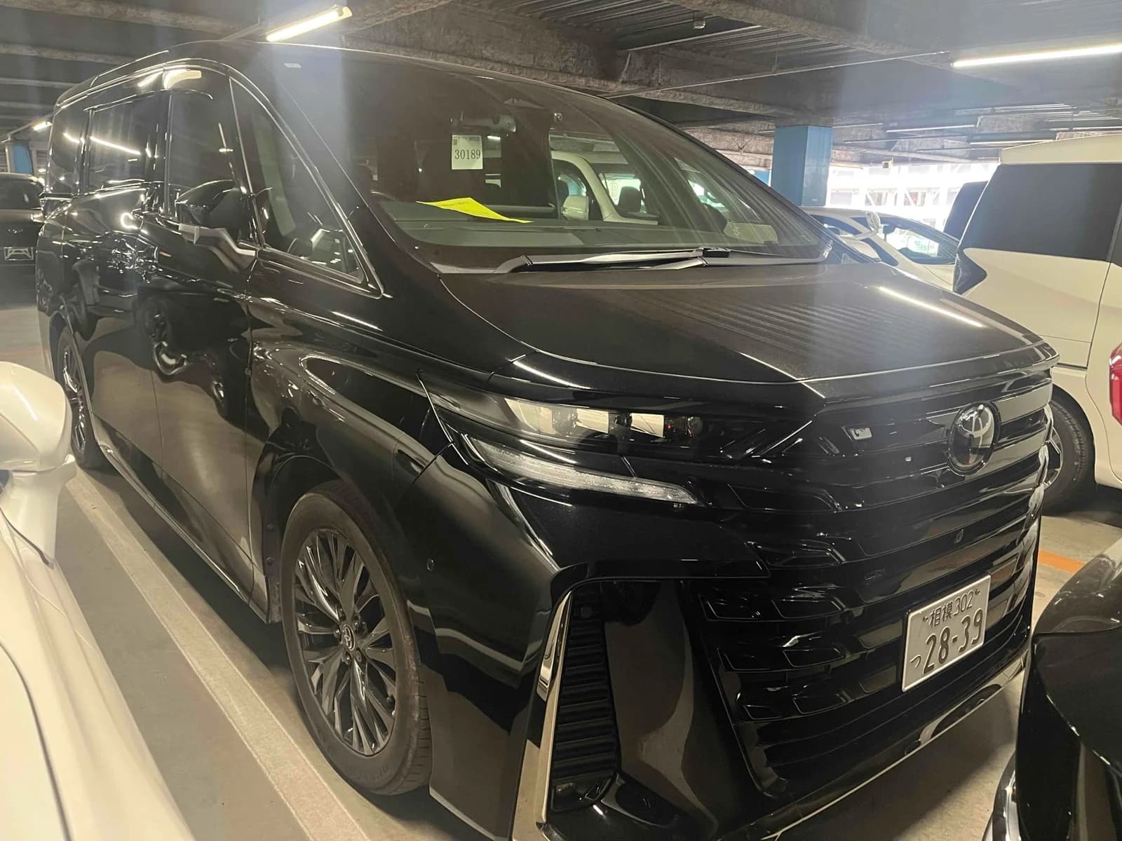 Black Toyota Alphard luxury minivan front-left three-quarter view at Japanese auction warehouse