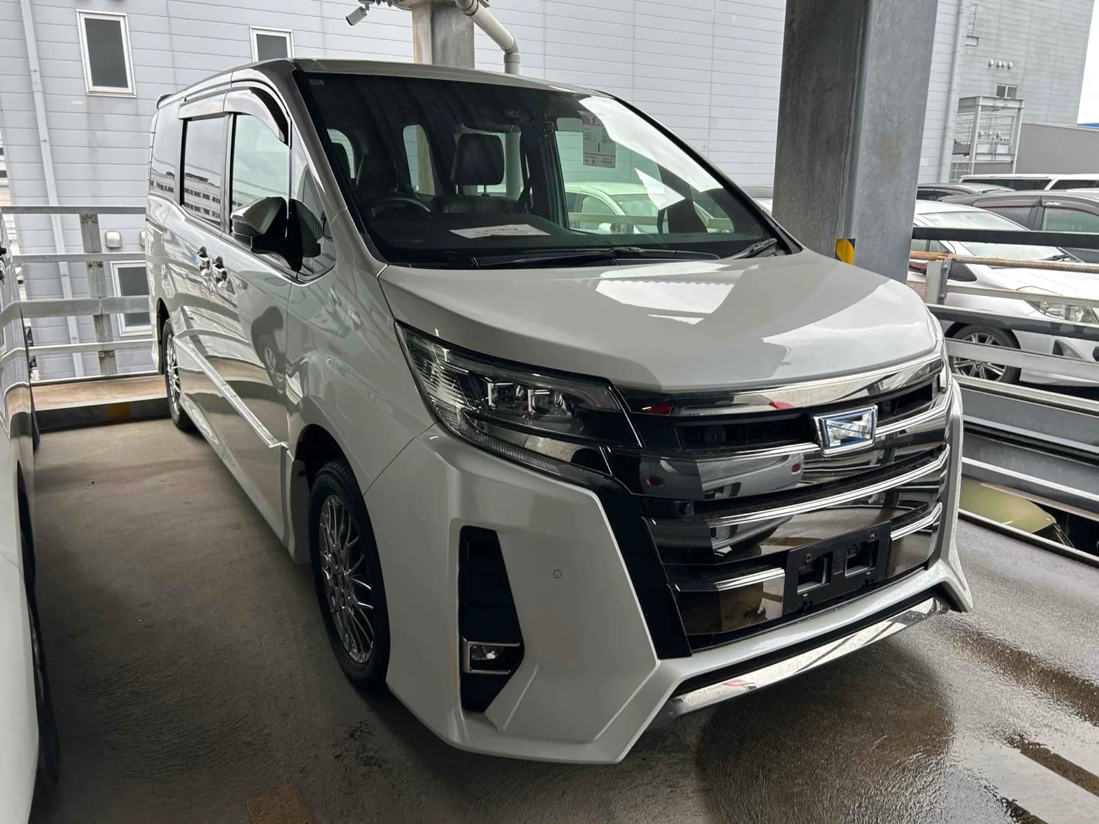 Toyota Alphard luxury minivan - Front-left 3/4 view showing white pearl paint, LED headlights, and premium design in warehouse