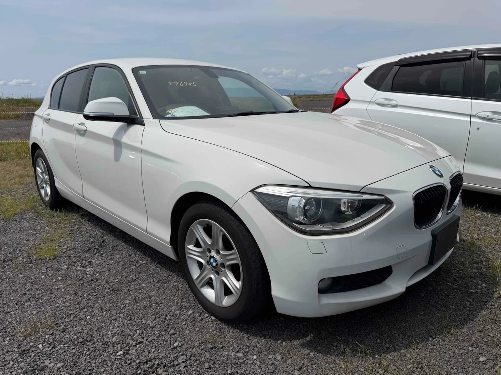 Front-left three-quarter angle of white BMW 1-series hatchback
