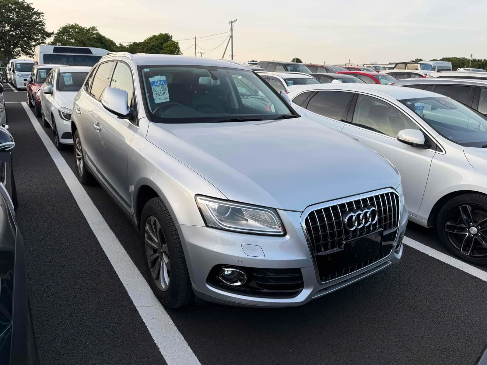 Front three-quarter view of a silver Audi Q5 SUV parked in a crowded auction lot