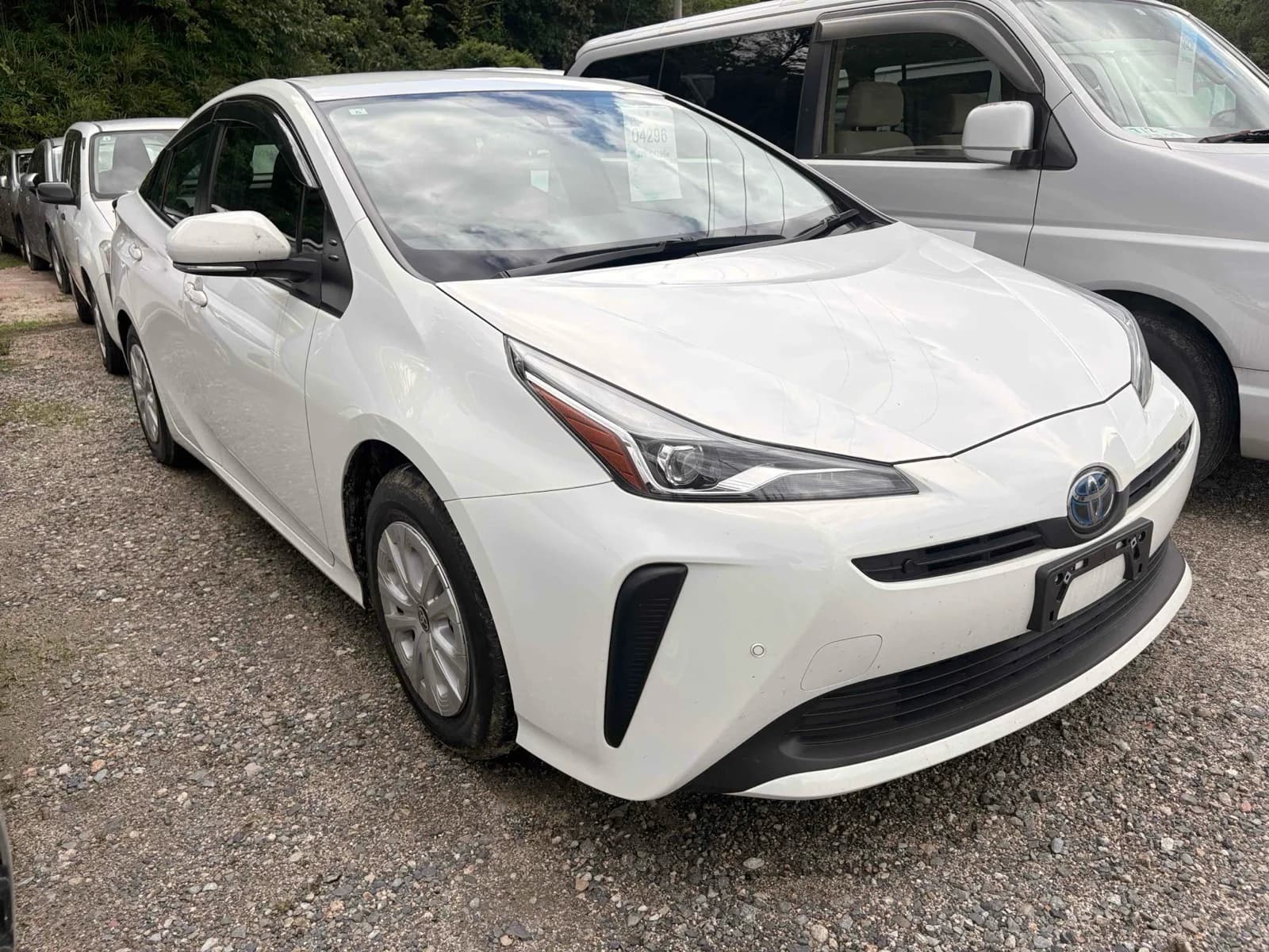 Toyota Prius hybrid hatchback - Front-left 3/4 view with white pearl paint, LED headlights