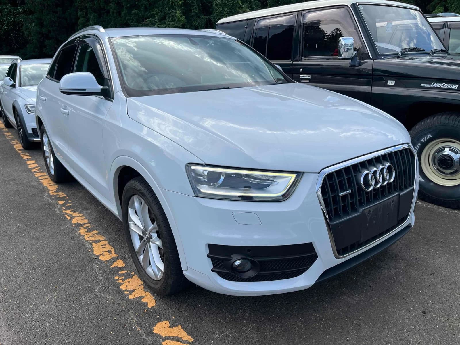 White Audi Q7 luxury SUV front-left 3/4 view at auction lot with LED headlights