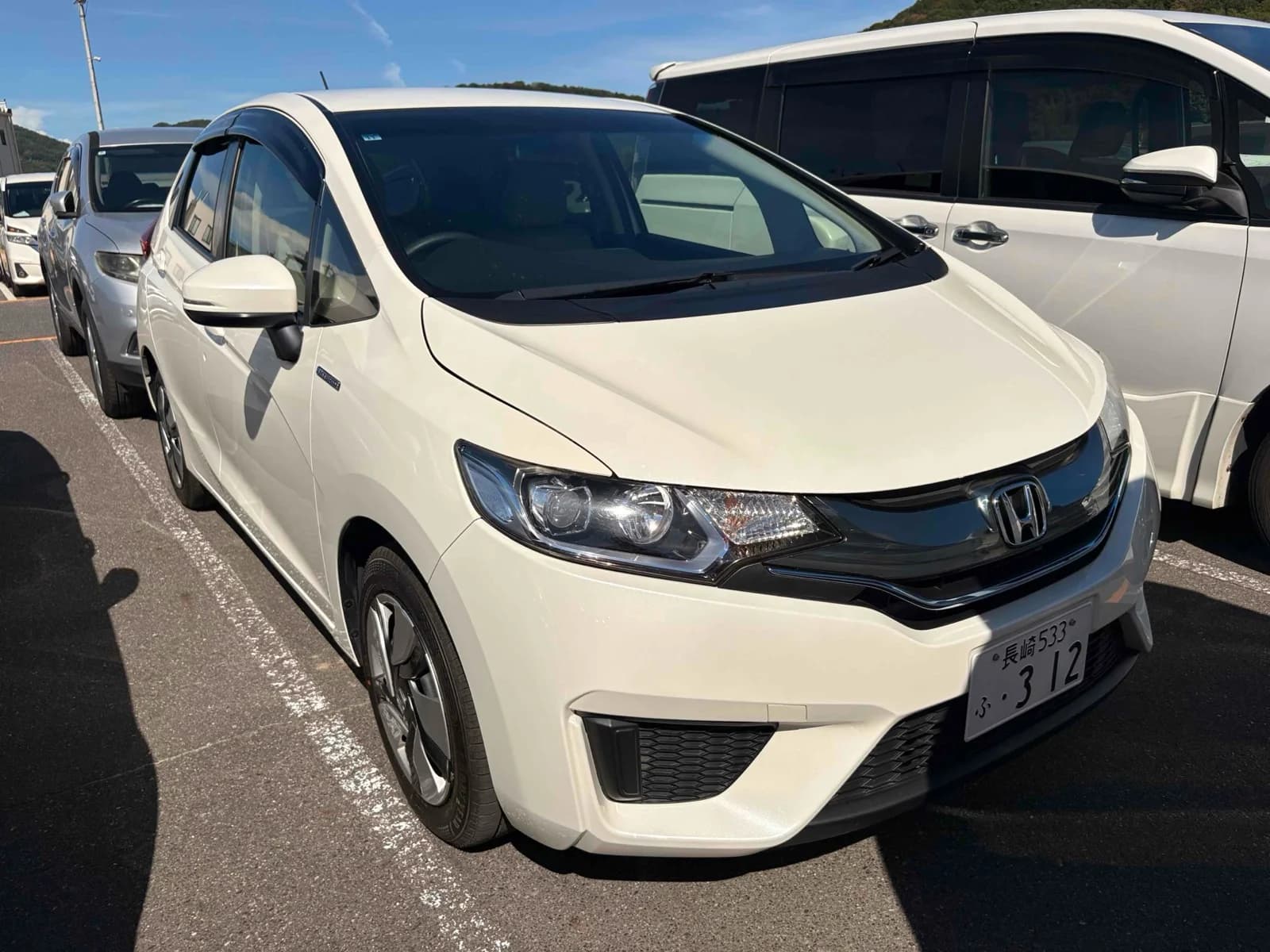 Honda Fit Hybrid - front-left 3/4 exterior view with white pearl paint and black accents