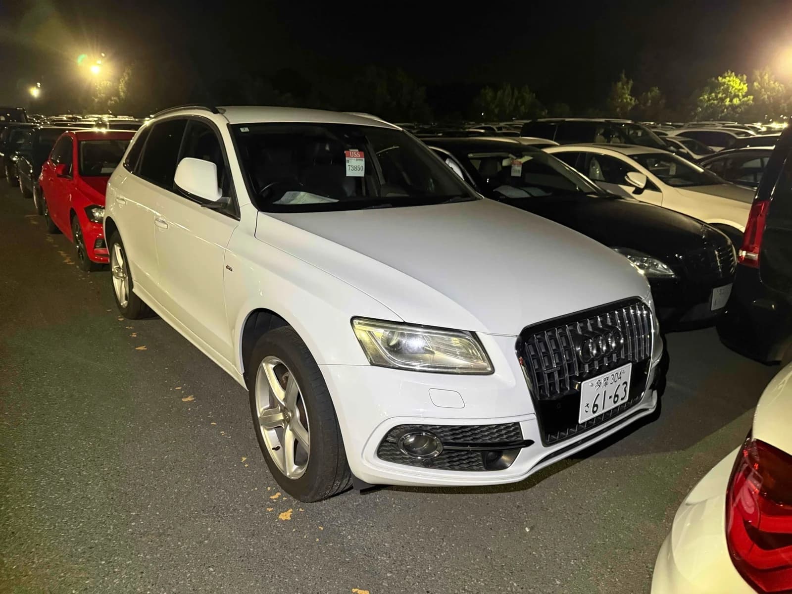 White Audi Q5 compact luxury SUV front-left 3/4 view at night auction lot with Japanese registration plate
