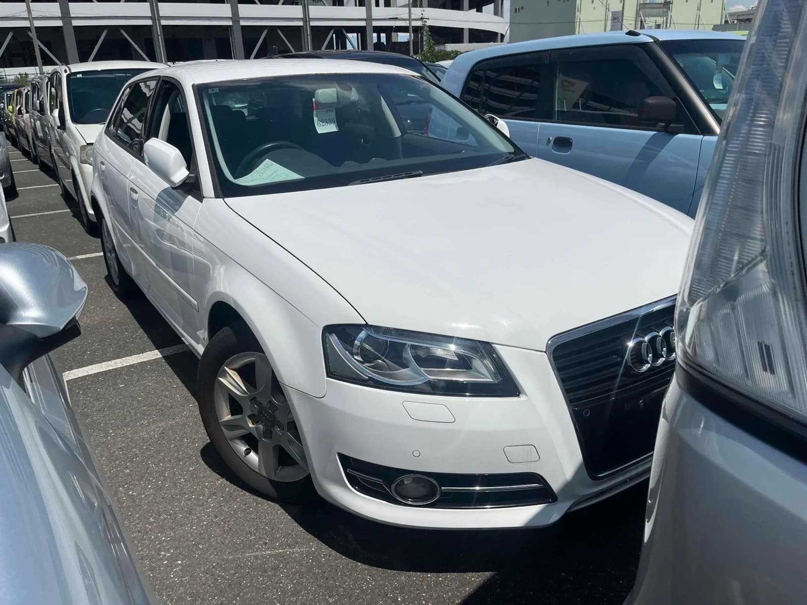 White Audi sedan - front 3/4 view in outdoor lot showing modern design