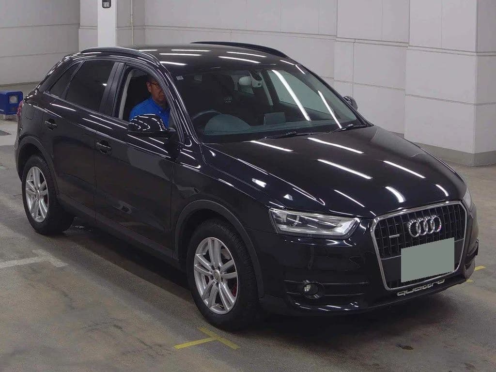 Black Audi Q5 SUV front 3/4 view in indoor parking garage with evaluator in driver's seat