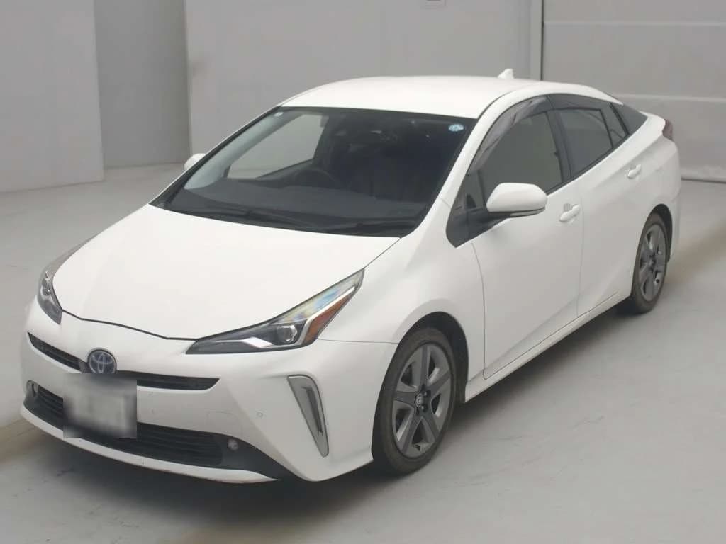 White Toyota Prius hybrid hatchback front-right three-quarter view in indoor photo studio