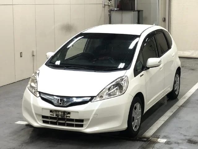 White Honda Fit compact car front three-quarter view in warehouse