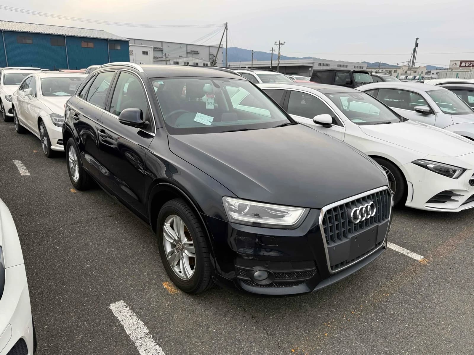 Dark navy Audi Q3 SUV front-right three-quarter view at outdoor auction lot with chrome grille and LED headlights