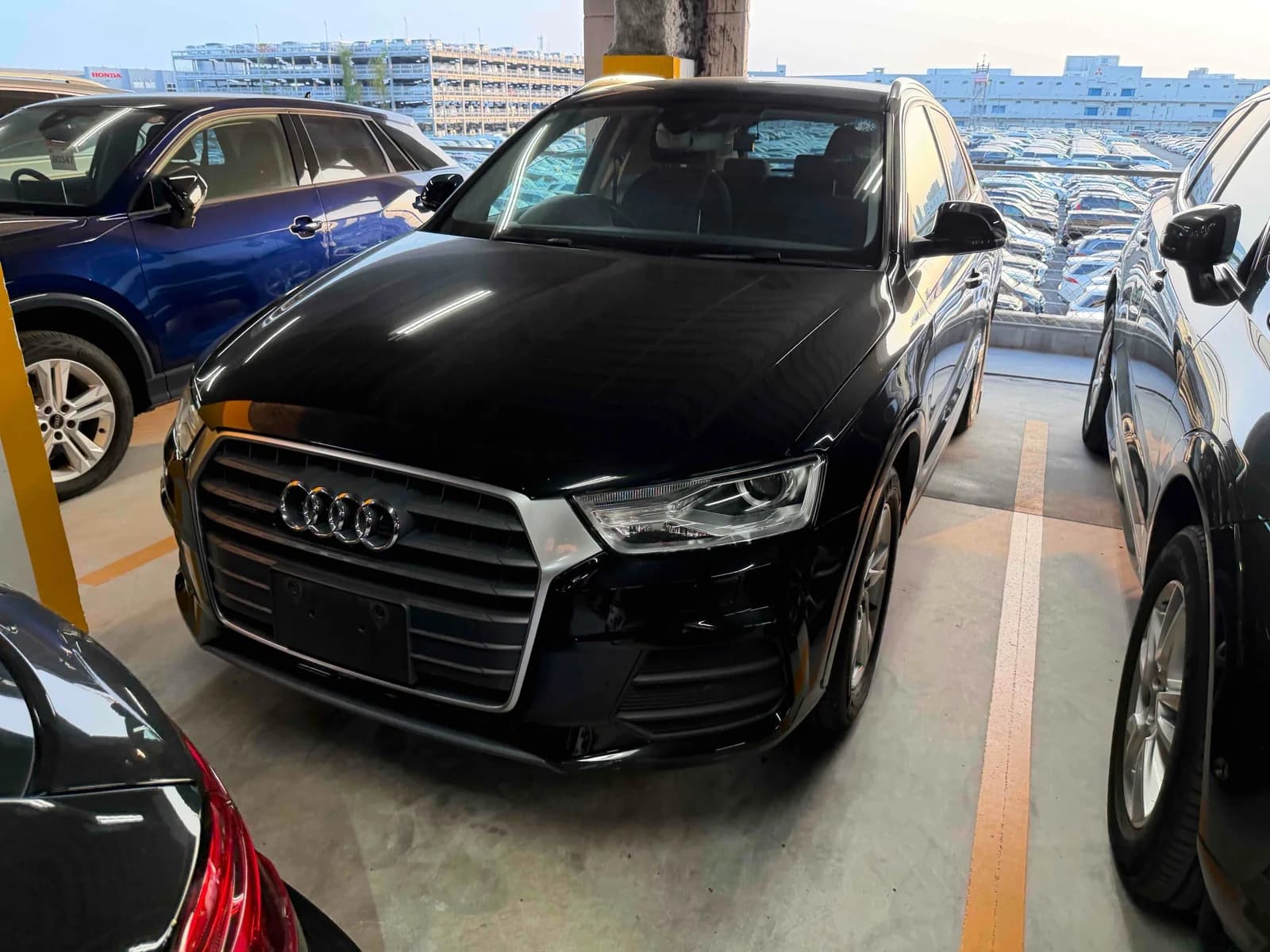 Black Audi Q3 SUV front-right three-quarter view in parking garage with chrome grille and LED headlights