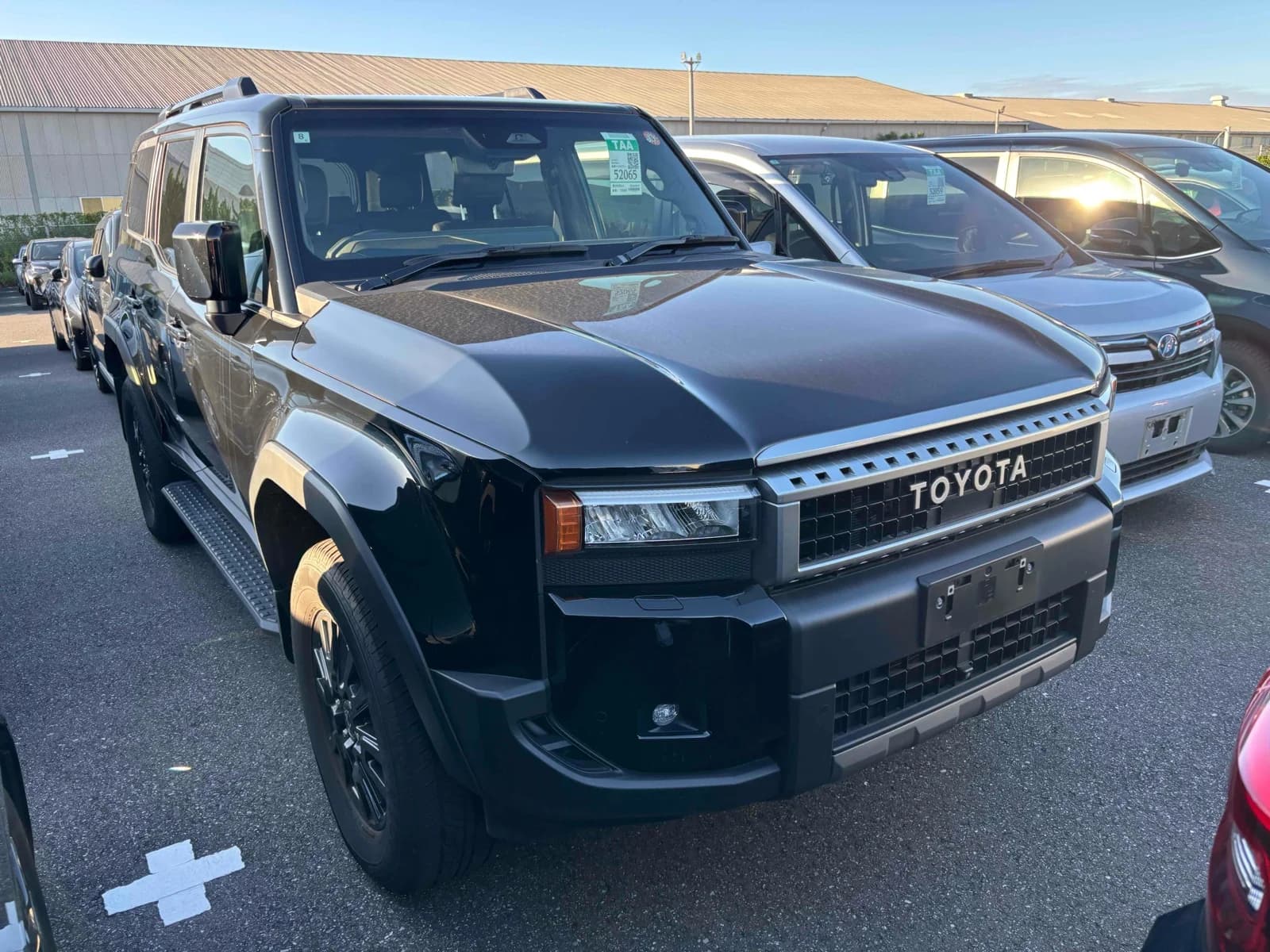 Toyota Land Cruiser 250 SUV - Front-left exterior view at an auction lot in black paint with LED headlights and black steel wheels