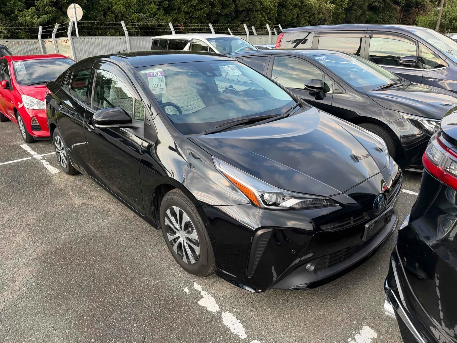 Toyota Prius Hybrid hatchback - Front-right exterior view with black paint, angular LED headlights, and Toyota emblem