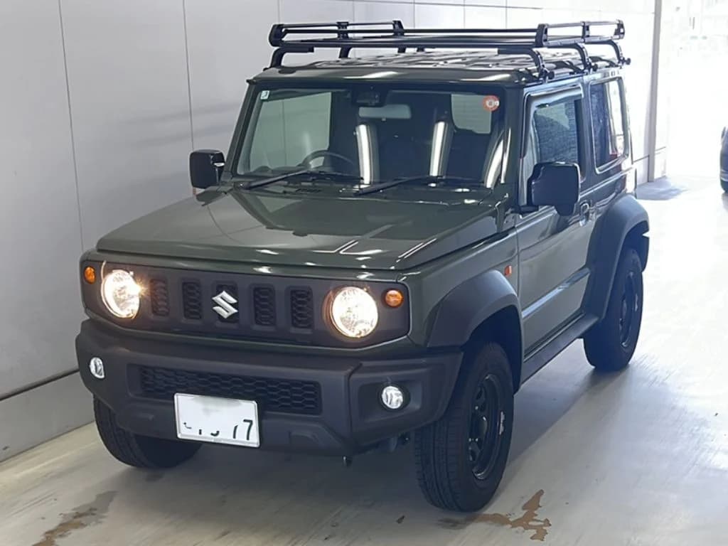 Suzuki Jimny SUV - Front-right exterior view with khaki green paint, round LED headlights, black roof rack, and black steel wheels