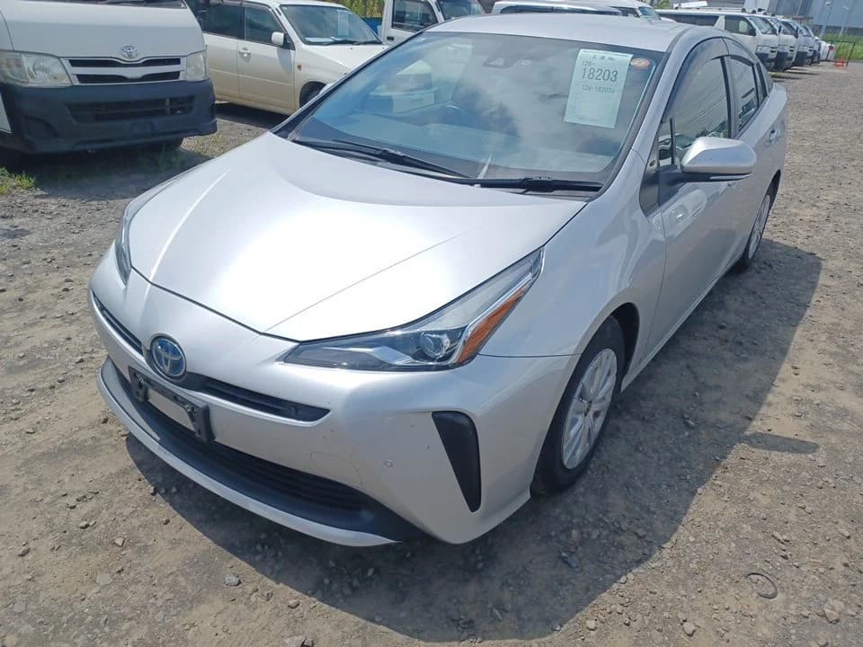 Toyota Prius Hybrid hatchback - Front-right exterior view with silver paint, angular LED headlights, and Toyota emblem
