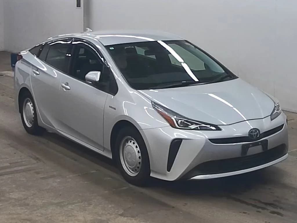 Toyota Prius hatchback - Front-left exterior view with silver paint, LED headlights, and steel wheels in an indoor garage