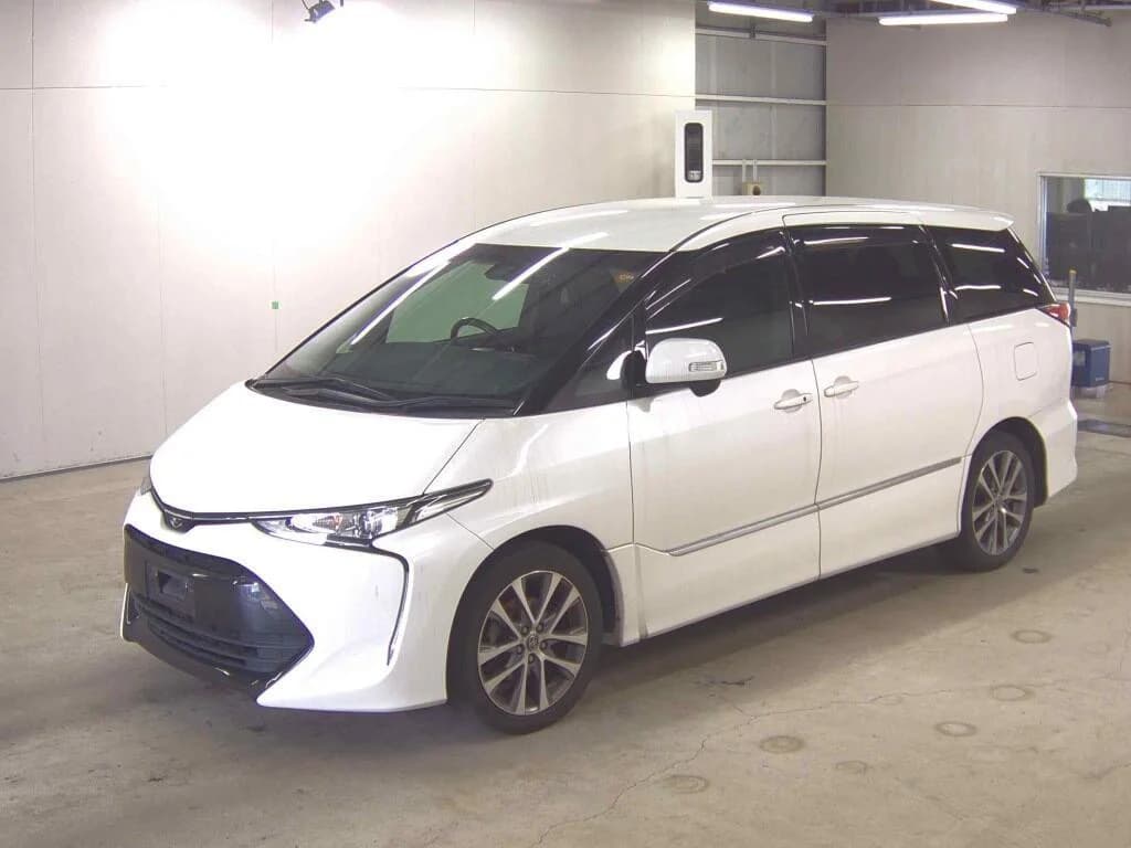Toyota Estima minivan - Front-left exterior 3/4 view with pearl white paint, black window trim, and alloy wheels