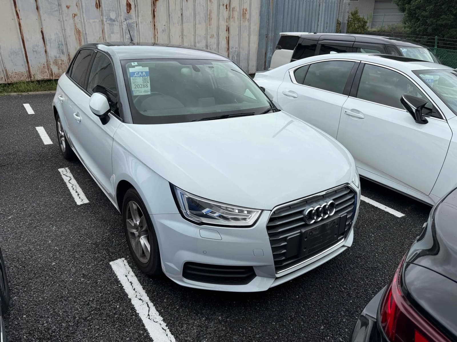 Audi A1 Sportback hatchback - Front-right three-quarter view in white with black roof, LED headlights, single-frame grille and alloy wheels