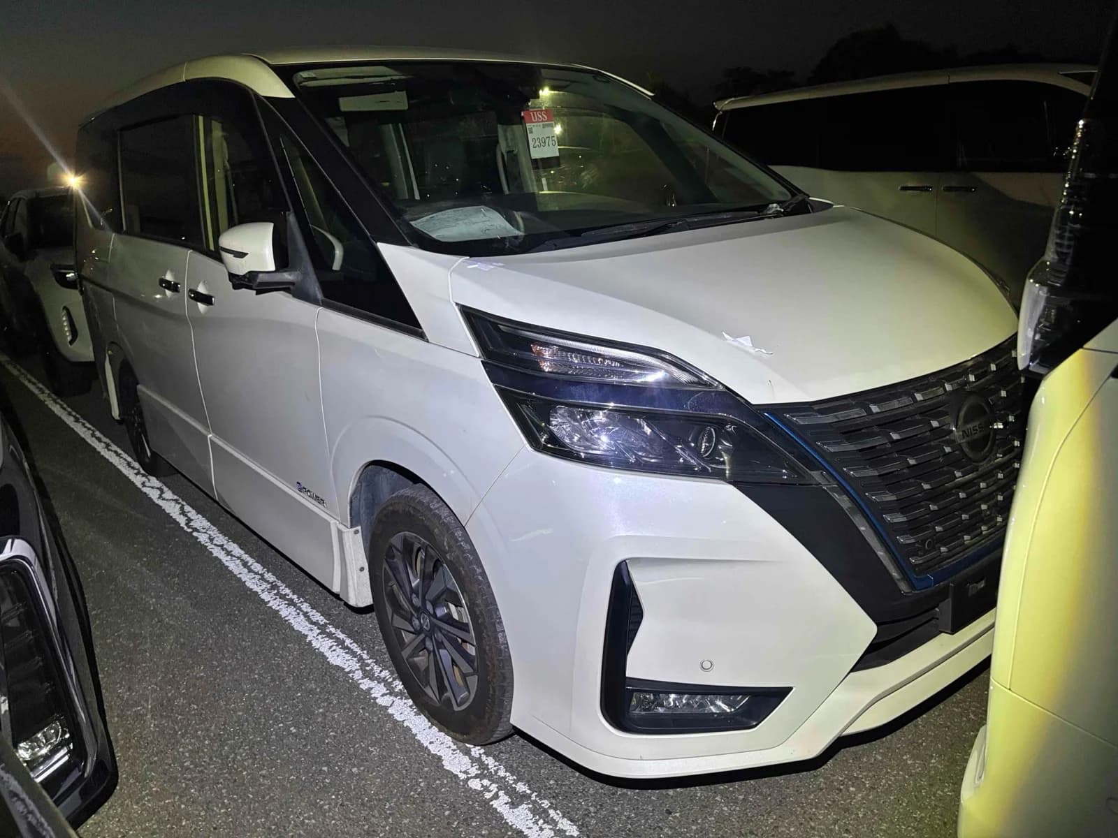 2020 Nissan Serena e-Power Highway Star V in pearl white - front-right 3/4 view with LED headlights, V-motion grille with blue accent, and dark alloy wheels