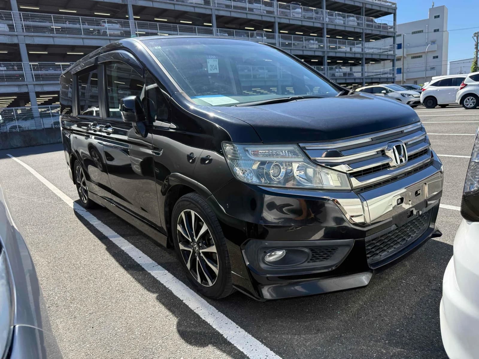 2013 Honda Stepwgn Spada Z Cool Spirit in black - front-right 3/4 view with chrome grille, projector headlights, fog lights, and two-tone alloy wheels