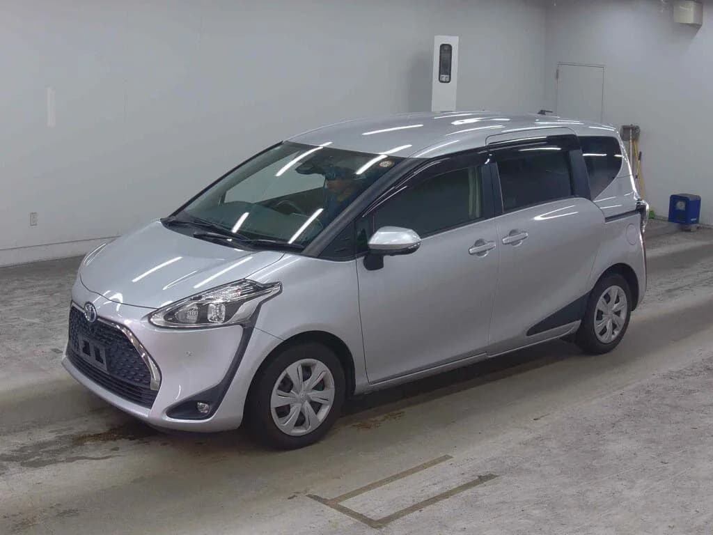 2021 Toyota Sienta Hybrid 7-seater MPV in silver - front-left 3/4 view with LED headlights, black mesh grille, sliding rear door, and steel wheels with covers
